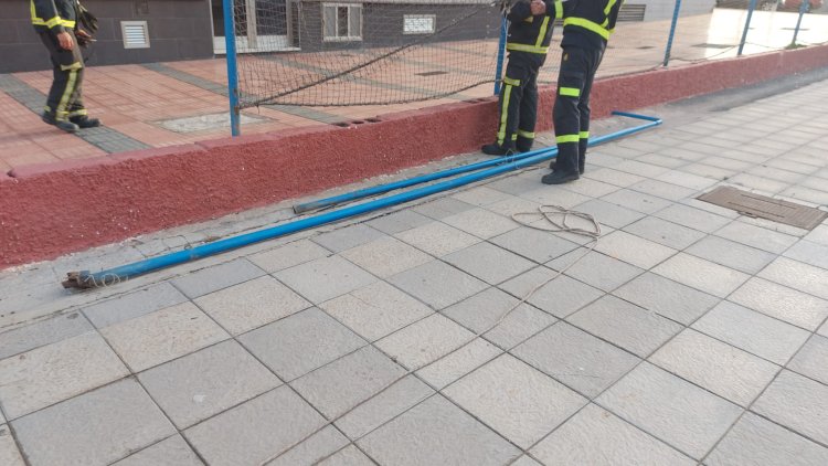 Los bomberos retiran un poste del vallado de la cancha de Marpequeña ante el riesgo de caída