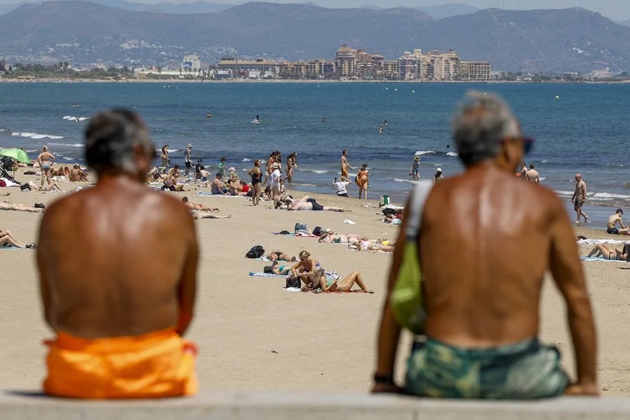 tempo Dos personas contemplan la afluencia en la playa de la Malvarrosa durante la mañana de este martes en el que se esperan máximas de más de 30 grados en la provincia de Valencia. EFE/Ana Escobar