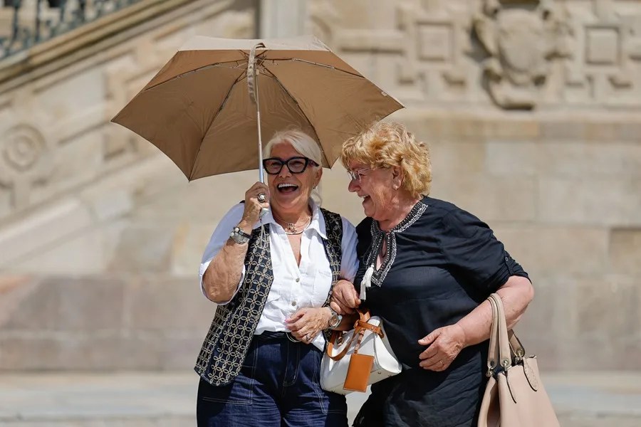 caloret Dos mujeres usan un paraguas para protegerse del sol