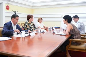 Participantes en la reunión sentados en una mesa